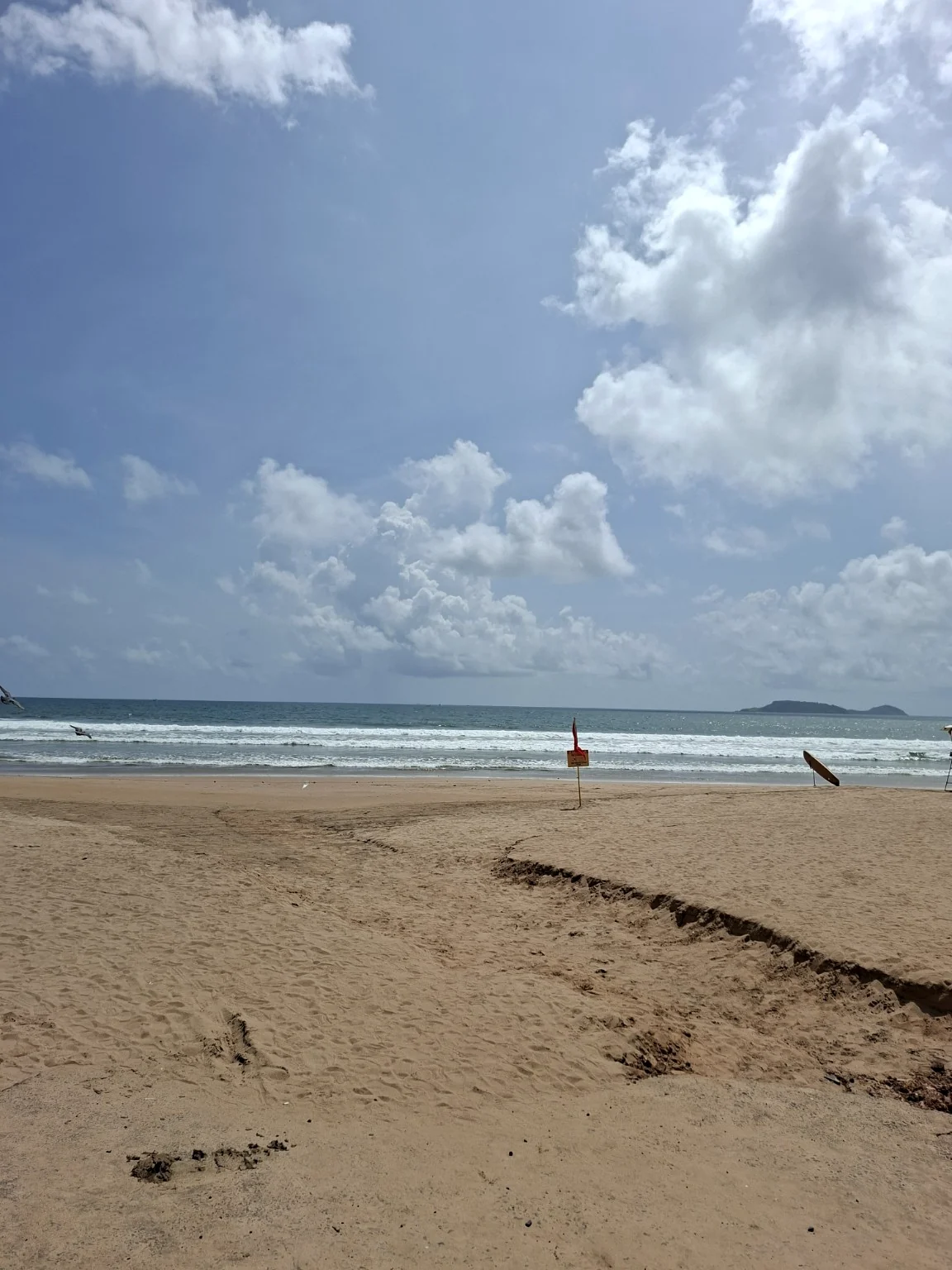 Waves and an open sandy beach in Goa, away from the property