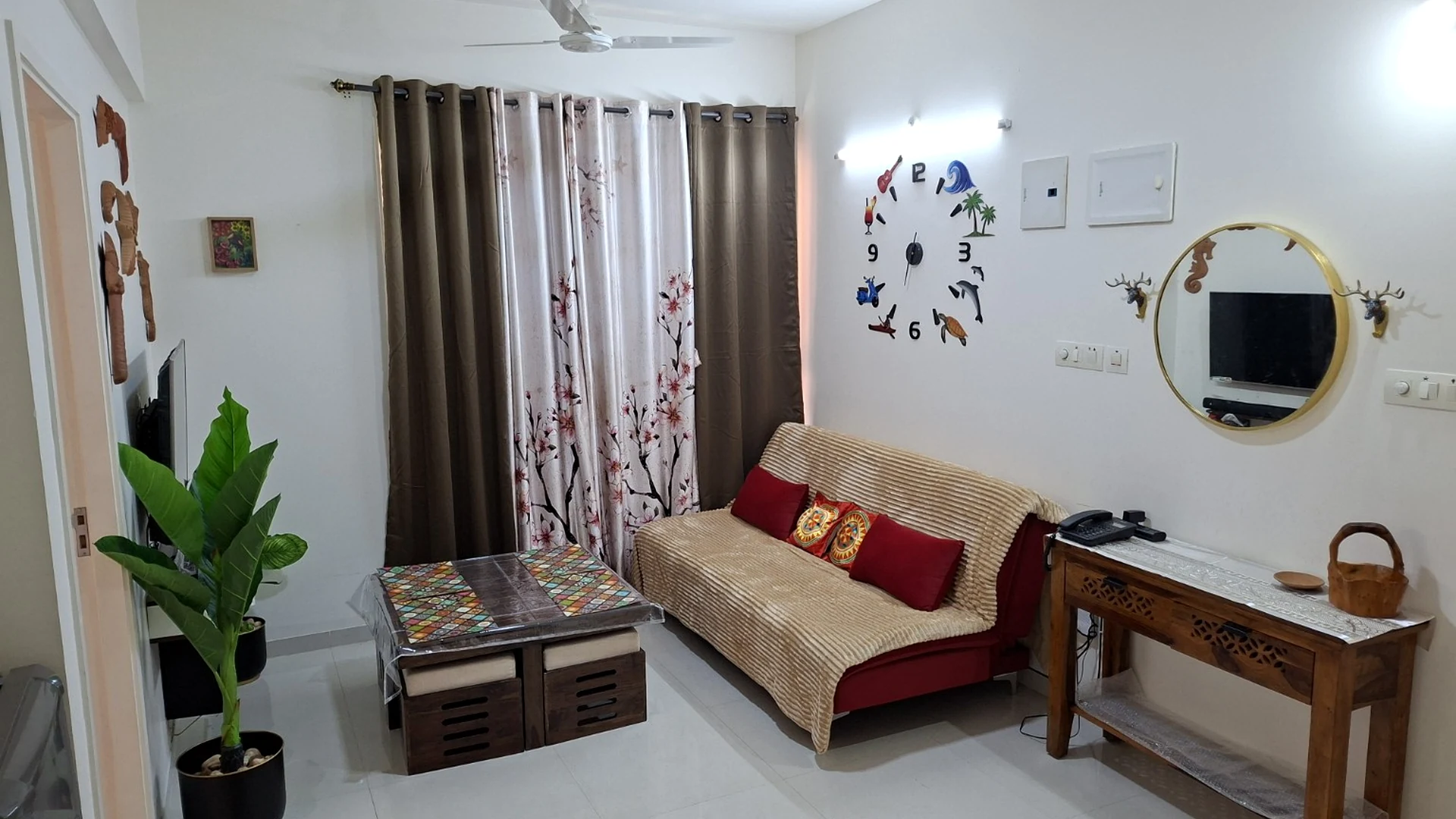 The Beginning living room, with a patterned coffee table, sofa and colourful wall decorations