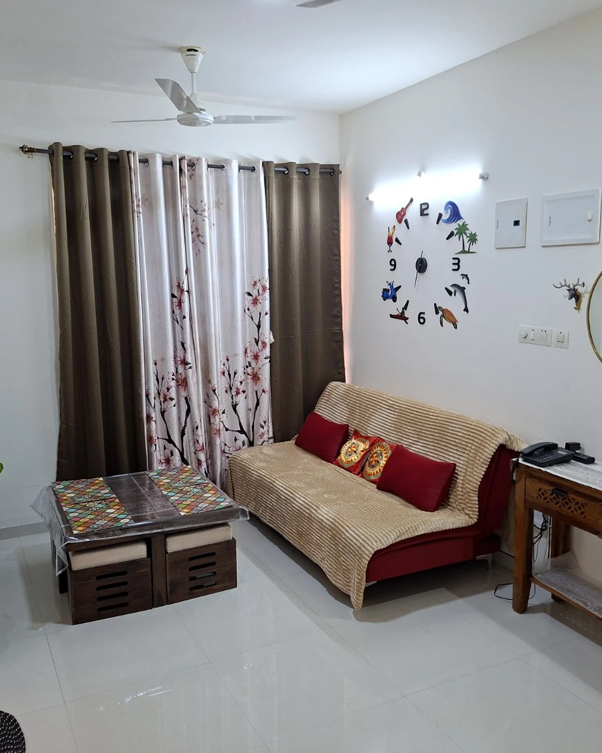 The Beginning living room with a sofa, patterned coffee table and personal wall decorations