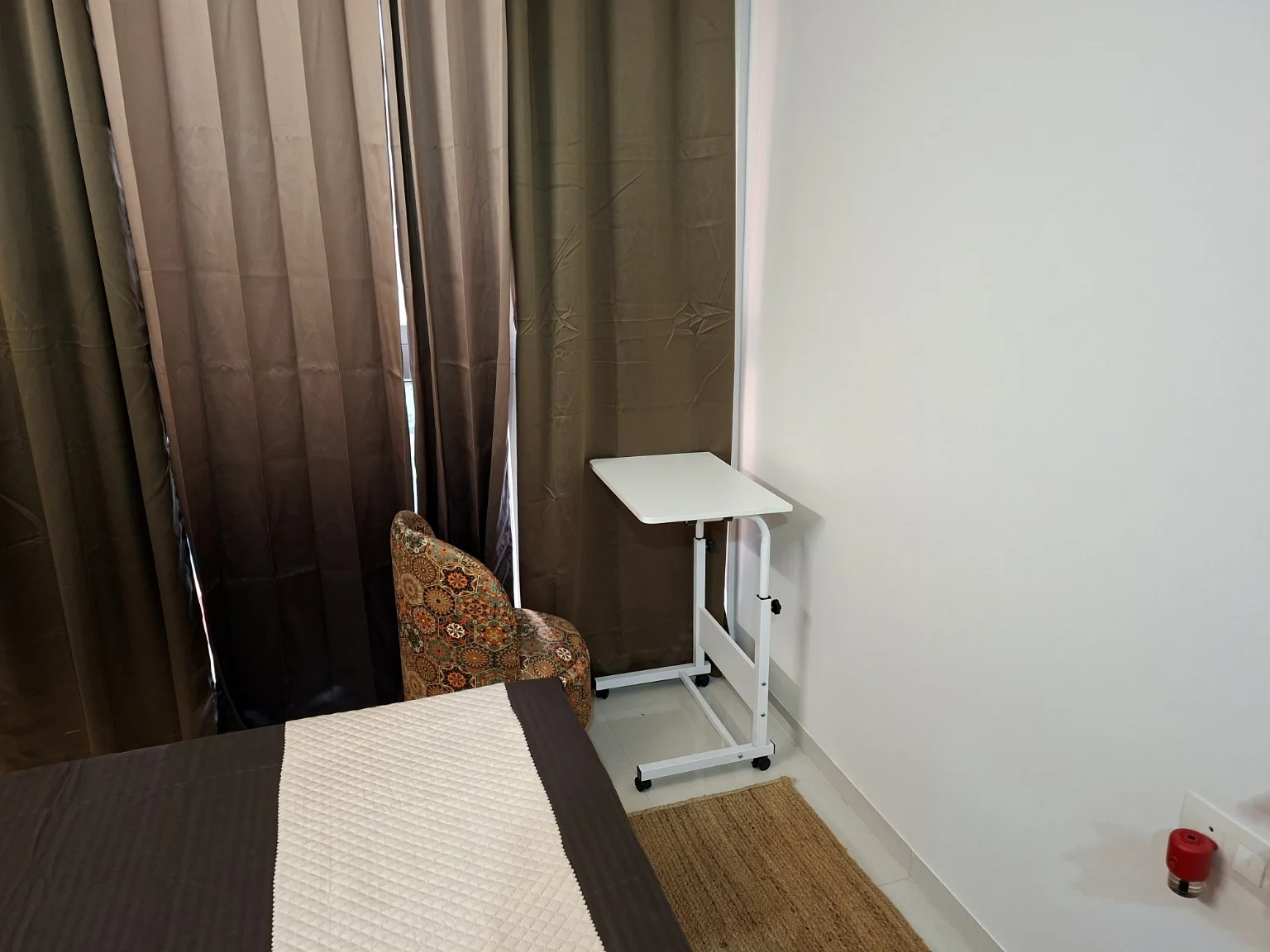 Compact work table and patterned chair beside the bedroom window