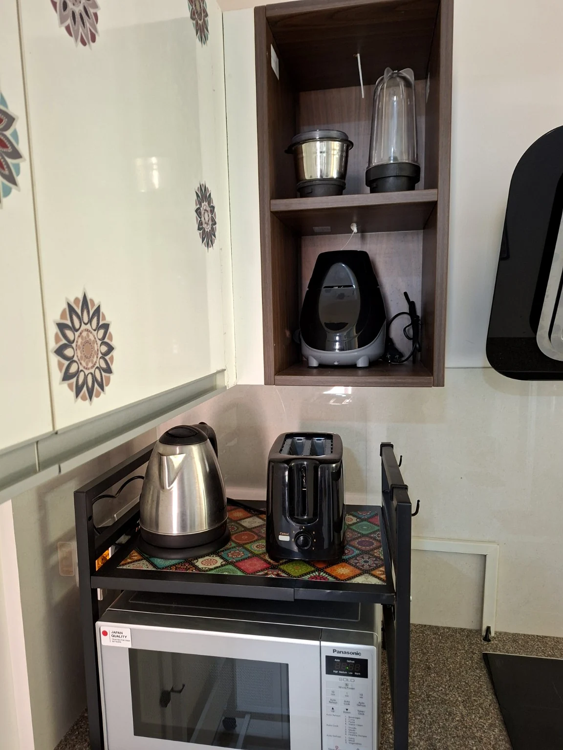 Kettle and toaster above the microwave, with mixer attachments on the shelf
