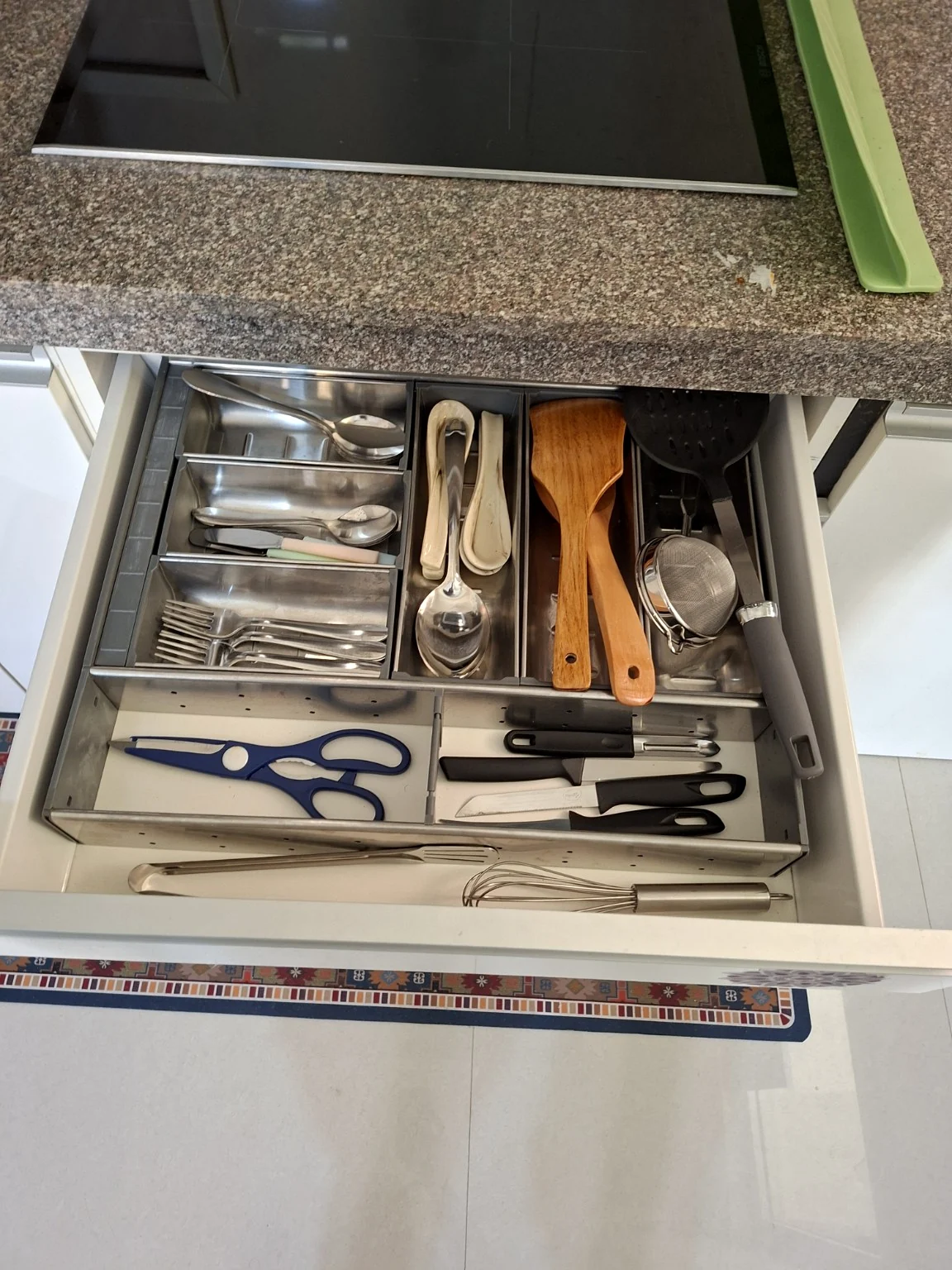 Organised drawer with cutlery, spatulas, a strainer and kitchen utensils